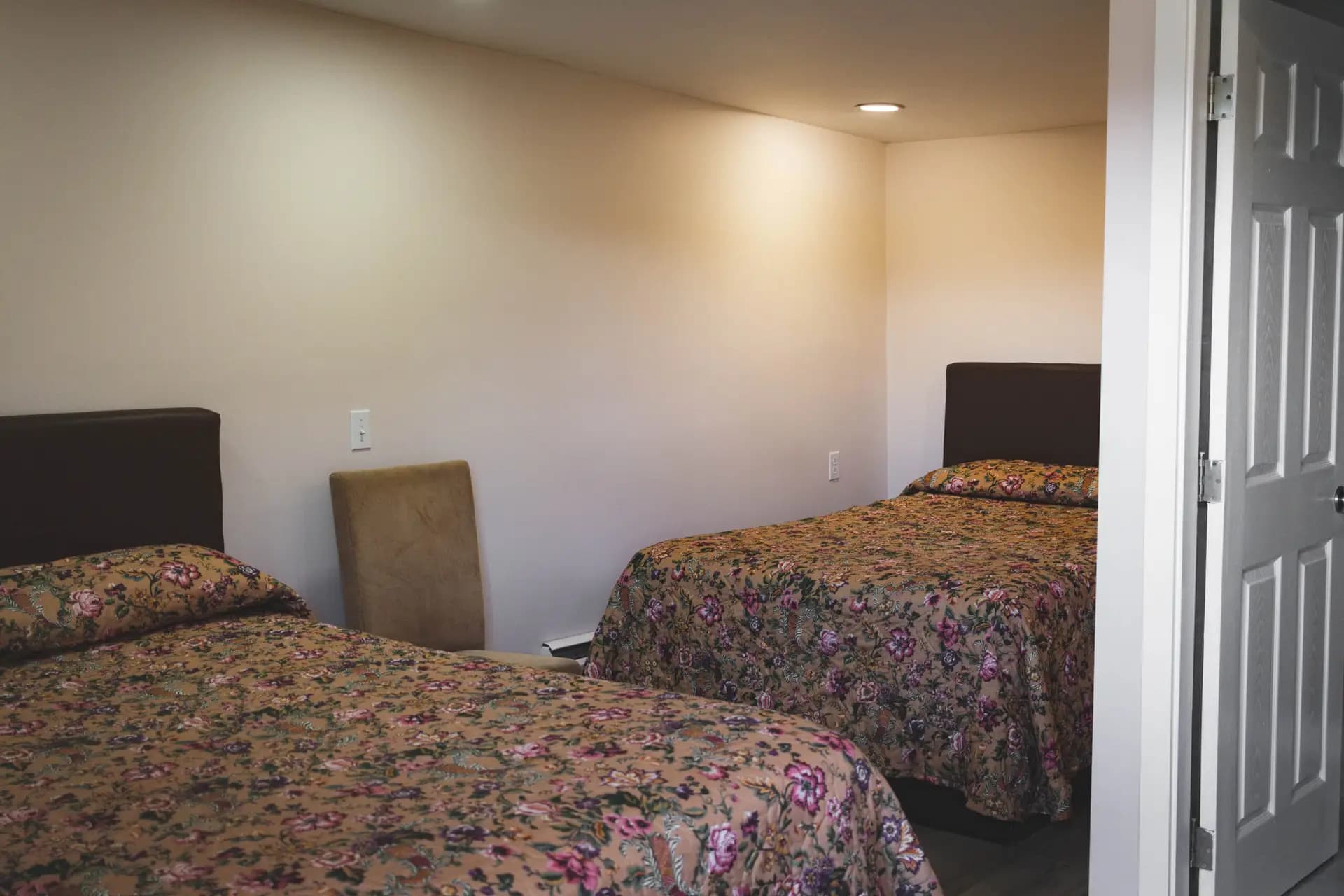 Double Room at Kluane Park Inn - Two queen beds and a small bathroom with a glass shower