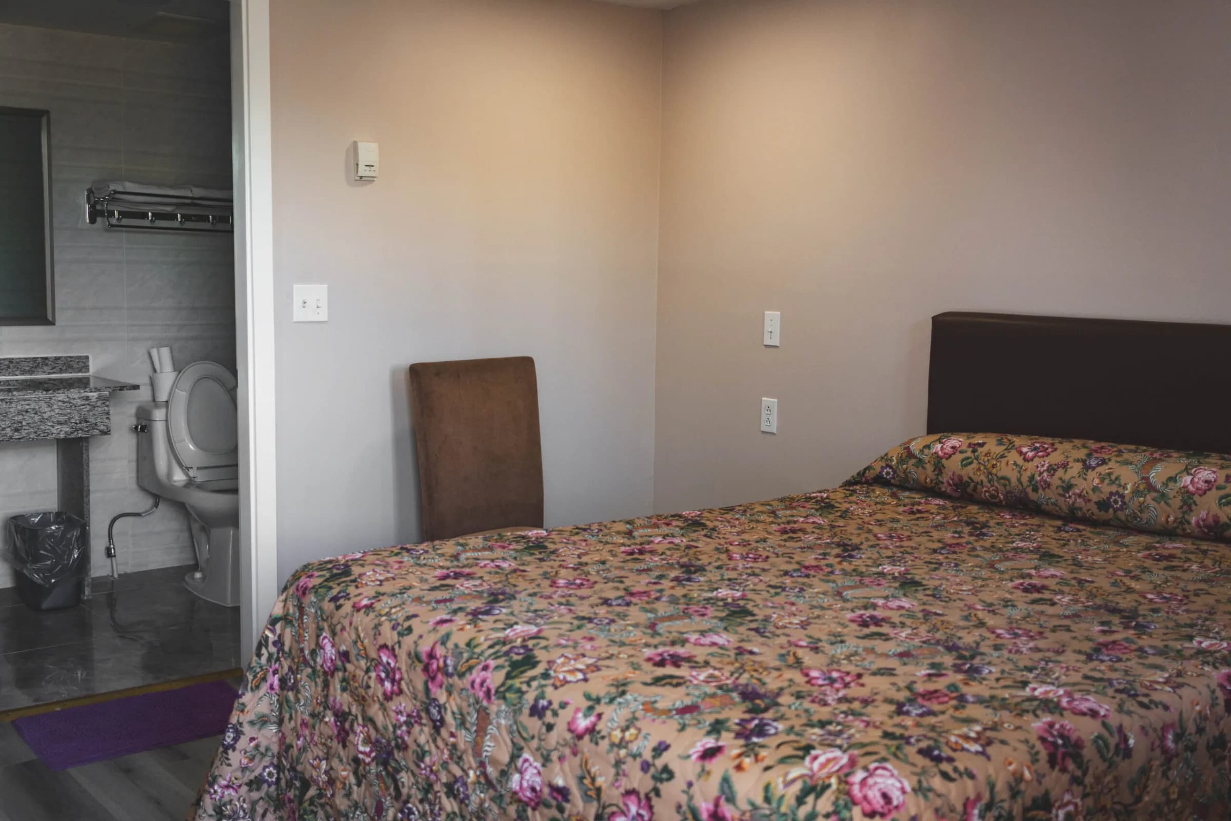 Single Room at Kluane Park Inn - Queen bed and a small bathroom with a glass shower